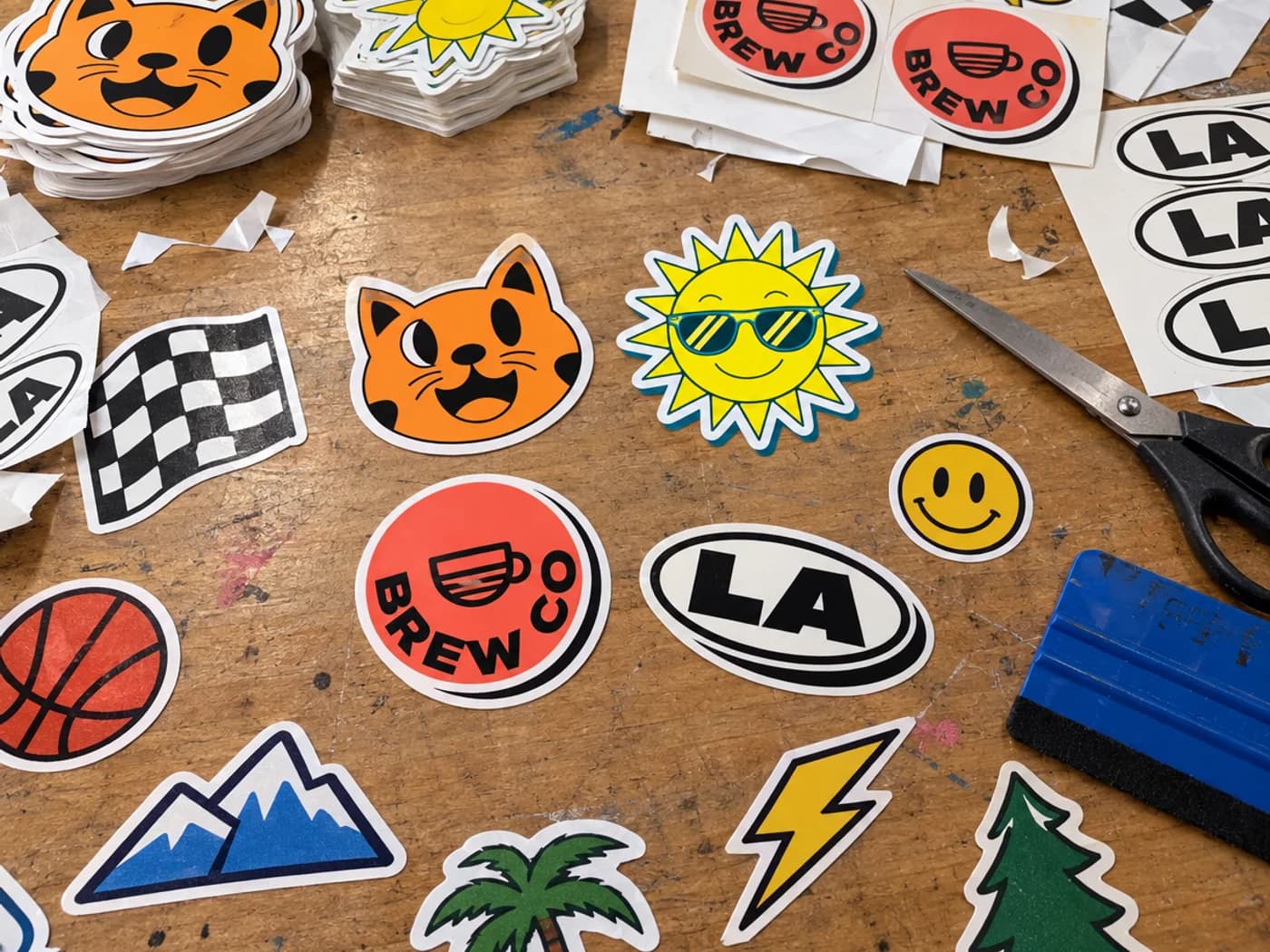 Freshly cut die cut stickers spread across the cutting table at StickerConnected